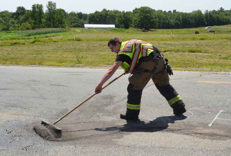 Camden Firefighter Jack Orestis cleans up the crash debris.