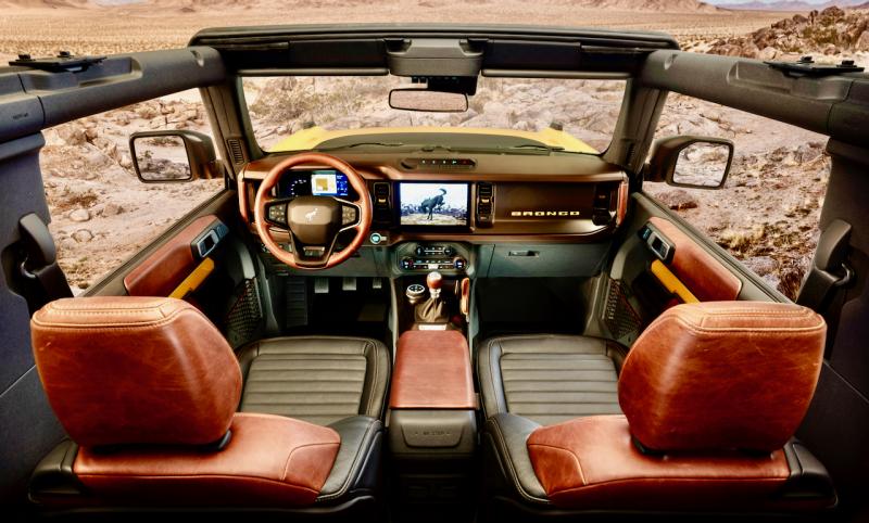 A topless Bronco, roll cage on display, with the 7-speed manual transmission. Note that the wing mirrors are mounted on the fenders, so they remain when the doors are removed (unlike a Jeep Wrangler). The leather interior is not necessary for a good time.