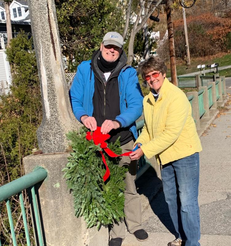 Doug Cole and Martha Bouchard hang wreaths on the bridge on Pascal Ave overlooking the harbor. (Photo courtesy Rockport Garden Club)
