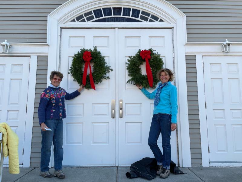 Martha Bouchard and Denise Munger add wreaths to the Rockport Opera House. (Photo courtesy Rockport Garden Club)