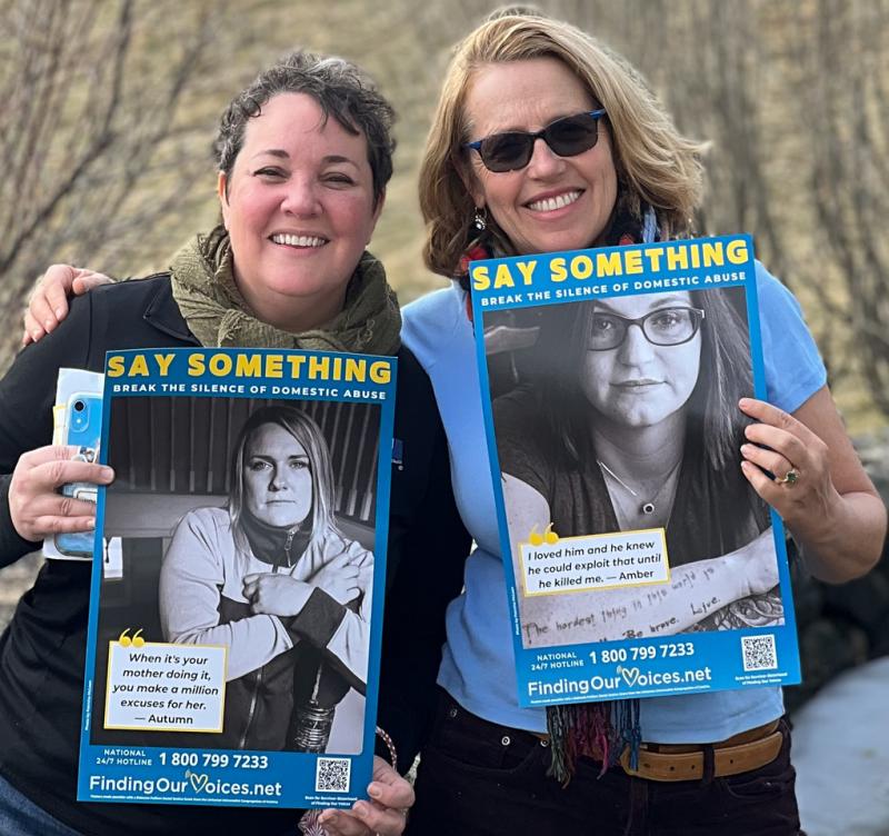 Kimberly Curry, Goodwill Communications Director, and Patrisha McLean, president/founder of Finding Our Voices, with two of the 400-plus Say Something domestic abuse safety posters. (Photo courtesy Finding Our Voices)