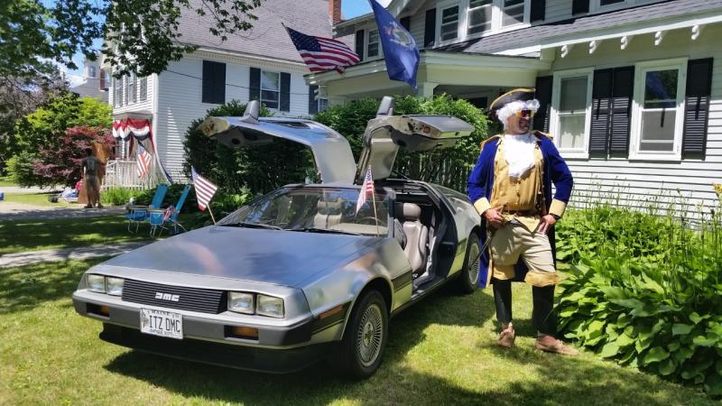 A local resident, or “George Washington” poses next to a DMC car, just like the DeLorean time machine in the movie Back to the Future. (Photo by Sarah Shepherd)