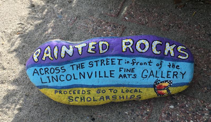 You’ll find Marge Olson’s painted rocks for sale in front of Dwight Wass’ gallery, and see Marge herself sitting at a table cluttered with paints and rocks-in-progress in her open barn door on Beach Road. If she’s not painting a rock she’s working in her several flower gardens, or maybe walking her deaf white boxer along the road. She communicates with her via signs!
photo by Diane O’Brien rock
