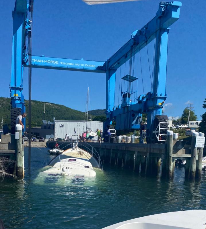 The vessel Bandwagon, with the Travelift slings around the hull, about to lift the boat out of the water. (Photo courtesy Steve Pixley, Camden Harbor Master)