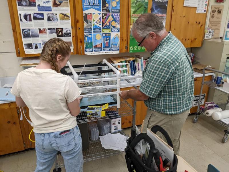 Belfast Marine Institute's student Laney Scheafe and teacher Chip Lagerbom assemble the lighting system for a kelp nursery aquarium. (Photo by David Thomas)