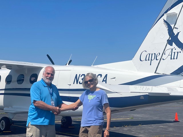 Cape Air Station Manager Rocky Stenger receives a congratulatory handshake from Knox County Commissioner Dorothy Meriwether. (Photo courtesy of Knox County Airport).