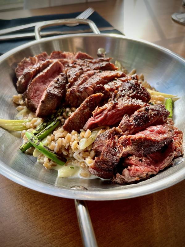 Ribeye Steak with Creamed Farro and Charred Garlic Scapes. Photo courtesy Aster & Rose