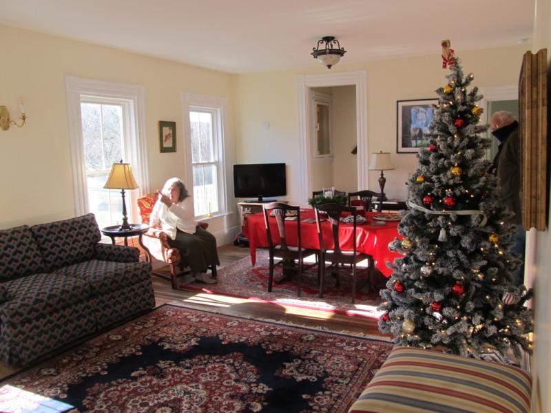 The refurbished room with donated furniture and a Christmas tree in 2022. Kathy Onofrio, is in the background. Photo by Kay Stephens
