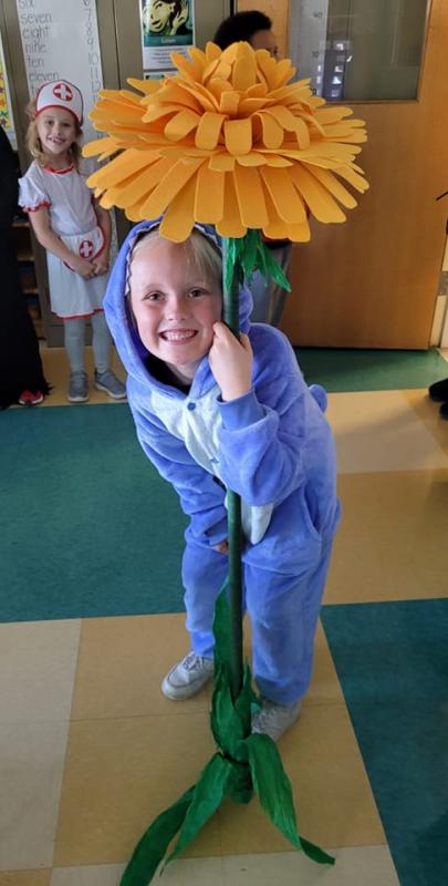 Adeline Willis, as Stitch, holds a larger-than-life dandelion. (Photo courtesy South School)
