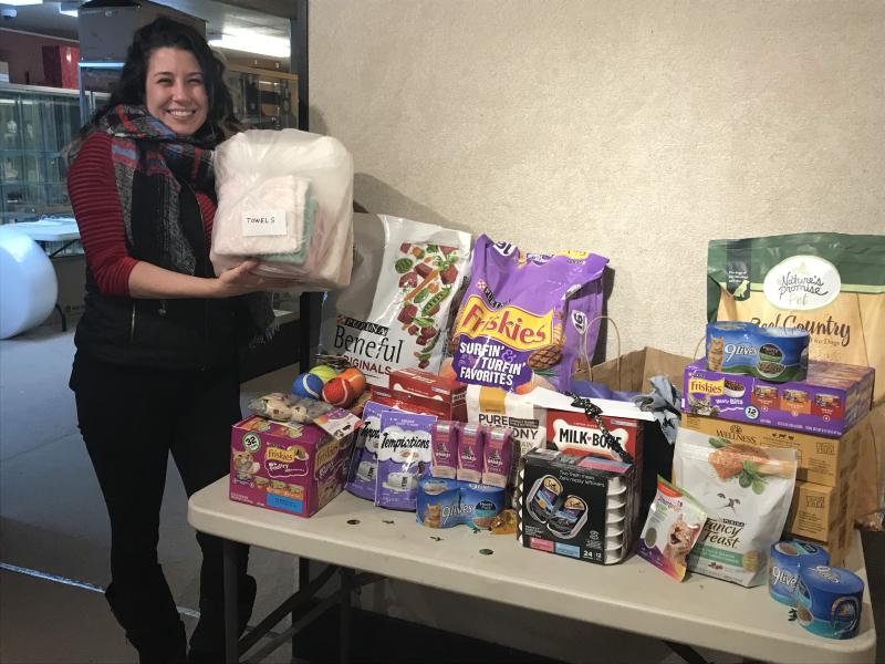 Front desk associate Kelsey Pryne with the items going towards the Pope Memorial Humane Society, Dec. 16. (Photo courtesy Thomaston Place Auction Gallery)