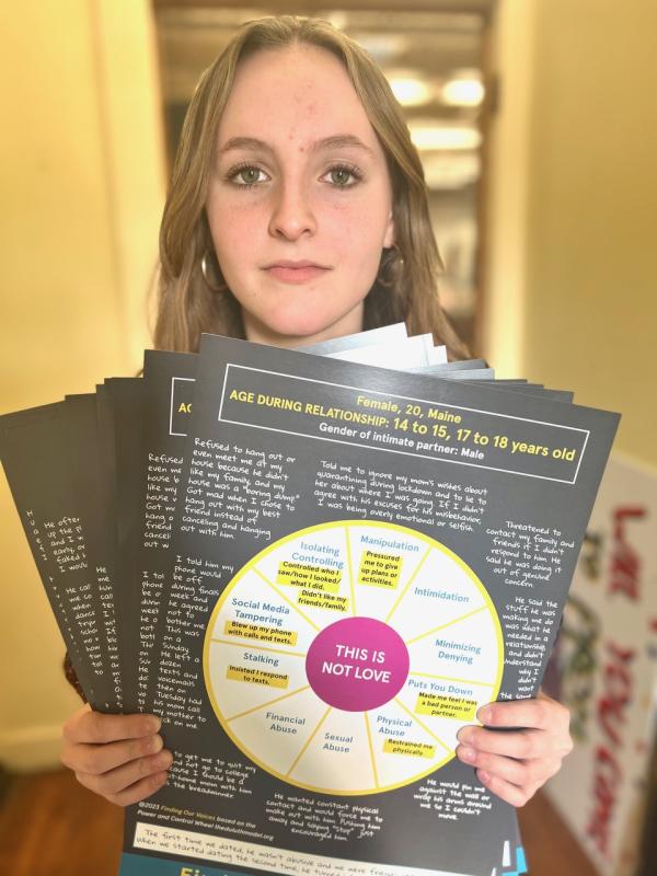 Aly Griffin, 16, with one of the 22 different posters she put up at Oceanside High School in Rockland. The Finding Our Voices posters are going this month to almost all high schools in Maine as well as some colleges. (Photo by Patrisha McLean)
