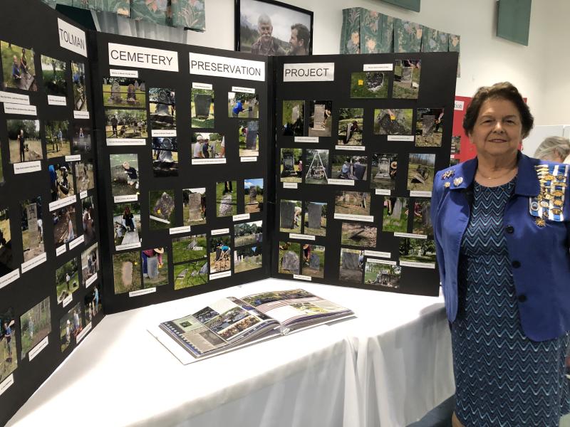 Chapter Regent Joanne Richards in front of Tolman Cemetery trifold. (Photo courtesy Lady Knox Chapter, Daughters of the American Revolution)