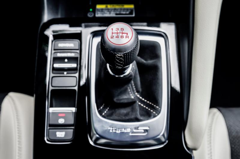 A rare sight now: a manual shift lever for a 6-speed gearbox. This one is stubby, perfectly positioned and operates with—pardon the cliché—the precision of a rifle bolt. Alongside are the electronic e-brake switch and the drive mode selector.