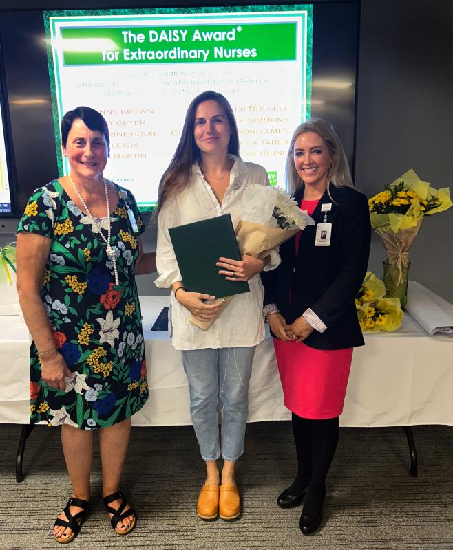 DAISY Award winner Katherine Holm, RN, Emergency Department nurse, stands with PBMC and WCGH Chief Nursing Officer Ellen Leone, RN, left, and PBMC and WCGH President Denise Needham, PharmD, after receiving her award during the DAISY and Sunshine Awards ceremony on Monday, Aug. 21, at PBMC. (Photo courtesy Pen Bay Medical Center)