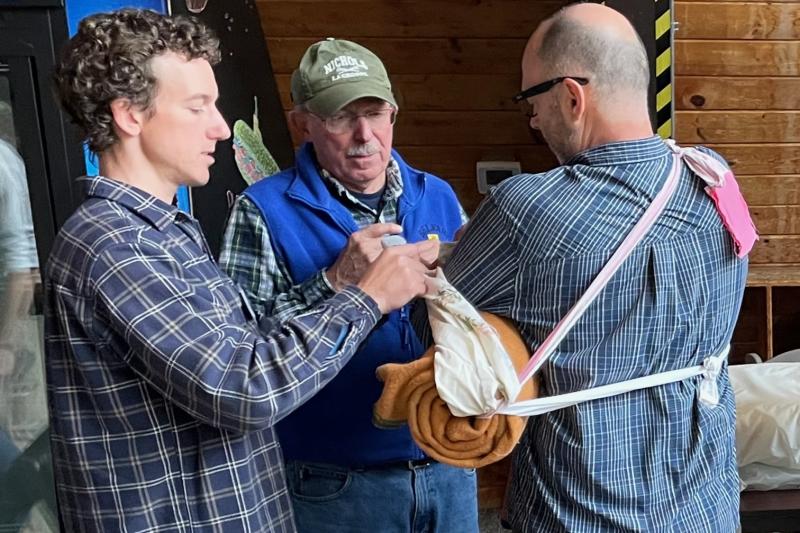 Ragged Mountain Ski Patroller Bob Winslow (center) teaches fellow patrollers Kris, from Black Mountain in Rumford, and Kevin Davis, also a Ragged Mountain patroller, in making injured skiers suffering arm injuries more comfortable before they are loaded into toboggans and transported down the mountain. (Photo courtesy Christine Nathan)