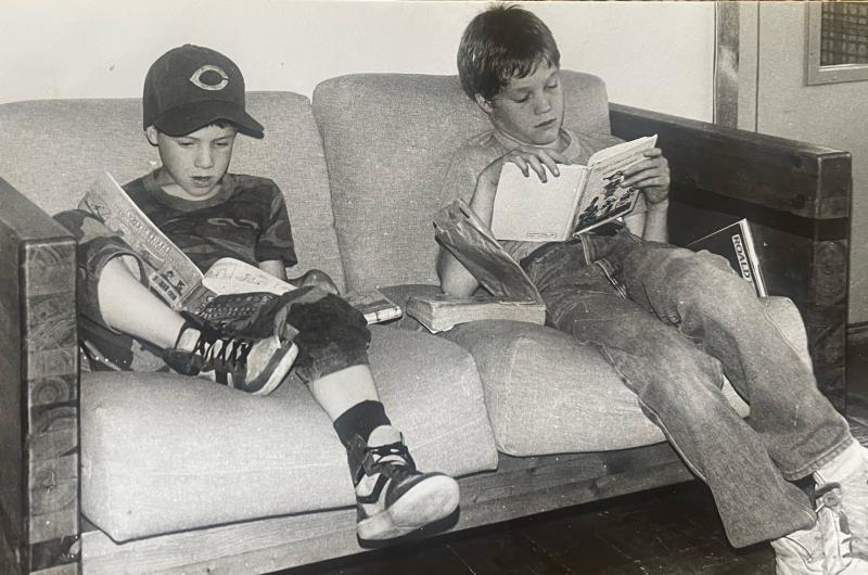 The author (right) waits for his mother to finish turning in her town news to the newspaper, circa 1985. (Photo by Diane O’Brien)