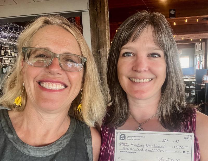 Patrisha McLean, CEO/Founder of Finding Our Voices, with Misty Mallar of Nautilus Seafood and Grill in Belfast. The $500 donation to Finding Our Voices represents 20 percent of sales of 250 slices of Limoncello cake sold during July. (Photo by Patrisha McLean)