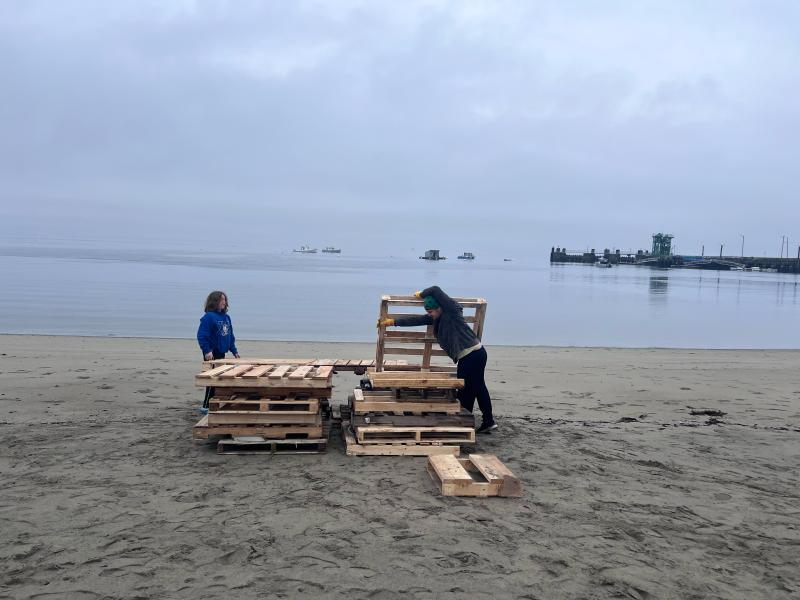 A couple Scouts start stacking pallets. (Photo by Ed O’Brien)