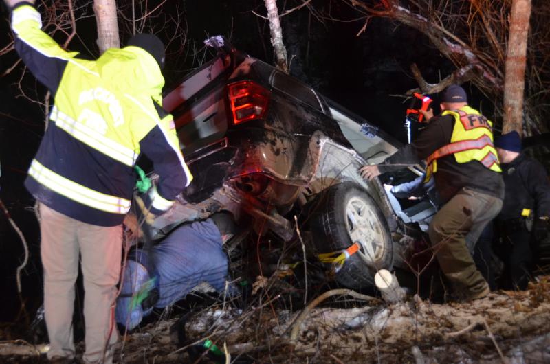 Rockport firefighters work quickly to stabilize the Jeep so that they can rescue the driver, as her vehicle hangs but five feet above the icy quarry. (Photo by Lynda Clancy)