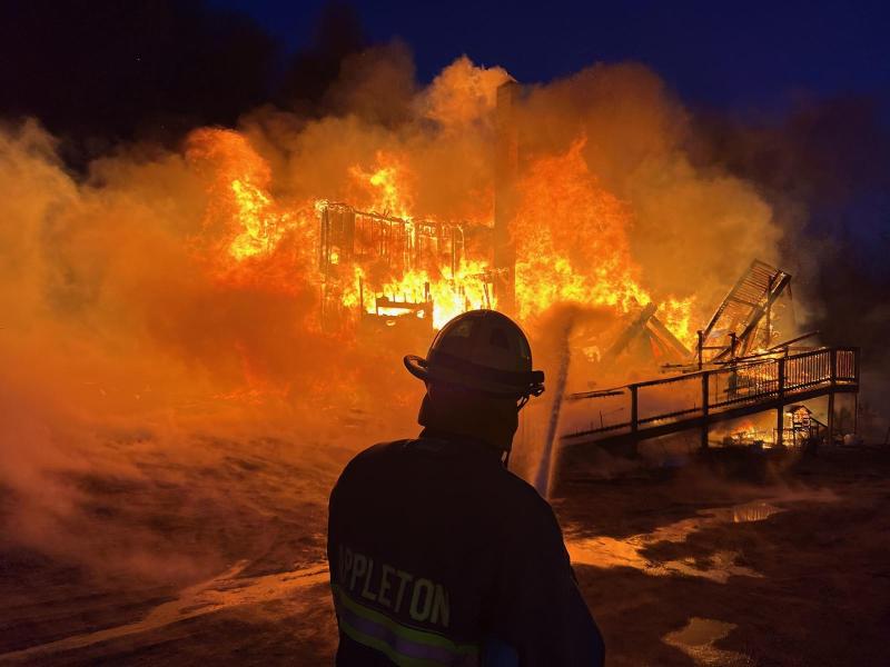 Liam Callahan, of Appleton Fire Dept., aims hose water at a structure fire at 163 Ghent Road, in Searsmont, Thursday, March 21. (Photo by Jonathan Ward, Lincolnville Fire Department)