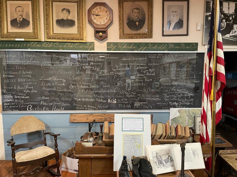 The blackboard in the schoolhouse museum, with the signatures of former students. (photo by Ed O’Brien)
