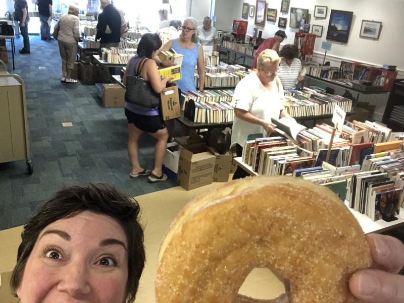 Rockport Library Assistant Director Julia Pierce enjoys a doughnut at last year's Donut Festival Book Sale. (Photo courtesy Rockport Public Library)