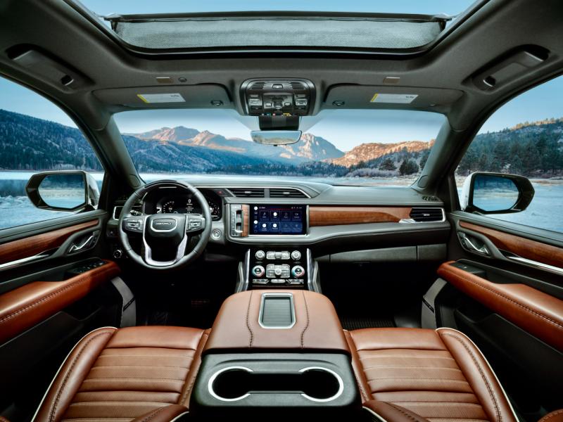 No, that’s not Mt. Denali in the distance, nor the Yukon Territory. Instead, focus more closely and note the Yukon Denali Ultimate’s luxurious and even tasteful Alpine Umber leather-swaddled cabin with many actual switches and buttons plus massaging seats, a 12-inch screen, inductive phone charger, ample storage space and power outlets, and (in the steering-wheel rim) the eyeball scanner that enables Super Cruise hands-free driving.