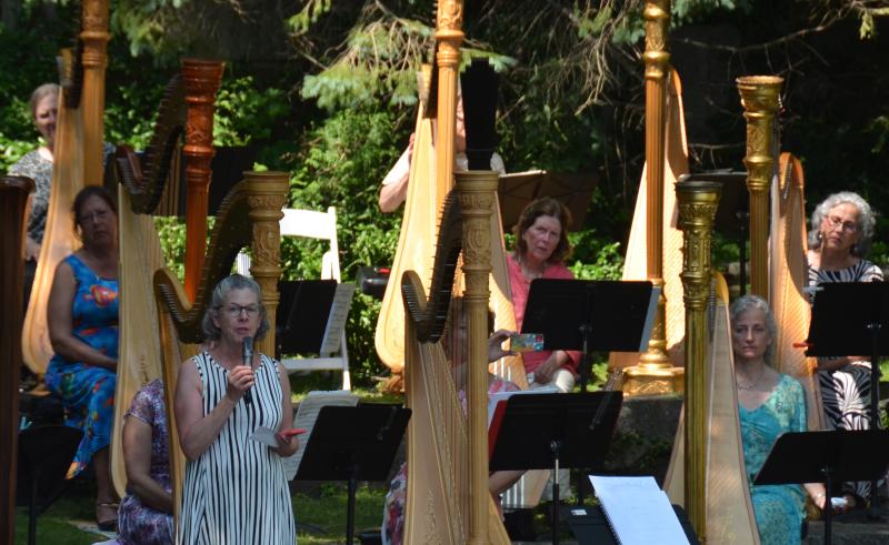 Kimberly Rowe, harpist and web editor at Harp Column magazine, welcomes the community Sunday afternoon, July 14, for a free concert at the Camden Public Library Amphitheatre, where decades ago, students would gather and hold similar concerts for the public. (Photo by Lynda Clancy)
