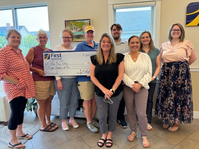 West Bay Rotarians and First National Bank staff celebrate The First’s sponsorship of the 2024 Duck Derby and upcoming Christmas tree sales events. From left to right are WBR’s Barbara Heard, Lisa Dresser, Club Secretary Kate Dullea, Club President Shelly Butler; First National Bank’s Niki Janczura, Jacob Clement, Chelsea Hatchey, Amanda Fisher, and Ashley Simmons.