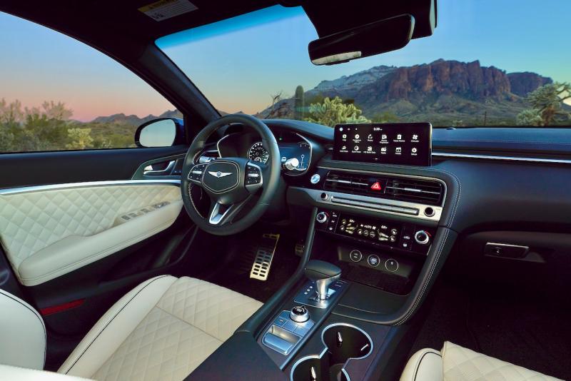 This is the Nappa leather and microsuede interior of the Sport Prestige upgrade as applied to the G70 3.3T. Aft of the gear-selector lever is the drive mode-selector knob and, below that, right where it should be, the e-brake switch.