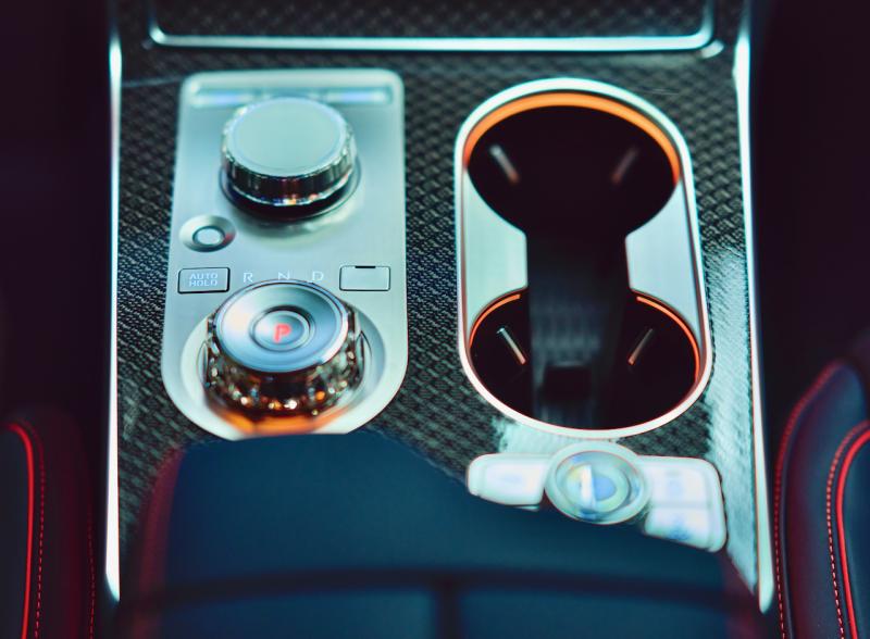 The GV80’s sole ergonomic flaw: The large, round gear-selector knob—the one with the red P-for-Park pushbutton in it—is too close to the large, round computer joystick, and I sometimes grab the wrong one. The switch panel below the cupholders is the drive-mode selector. Genesis console