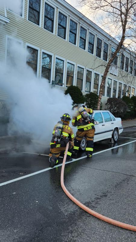 Camden firefighters tackle the car engine fire with water. (Photo courtesy Camden Fire Dept.) Dousing the car fire