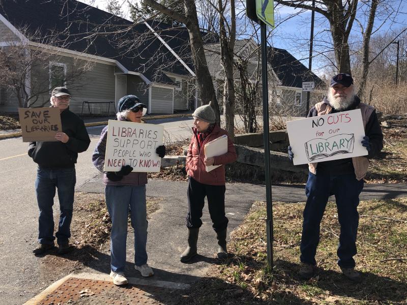 A group of protestors show their support for the Waldoboro Public Library on April 10. (Sarah Masters photo) A group of protestors hold signs supporting local libraries