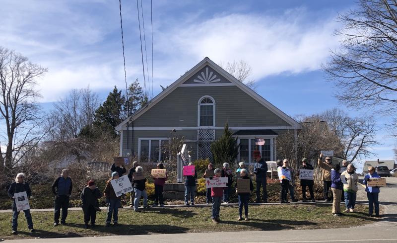 About 30 protestors waved at passersby in Waldoboro on April 10 as part of an effort to bring attention to Federal funding cuts which have impacted library services. (Sarah Masters photo) a crowd of library supporters in front of the Waldoboro Public Libraryy