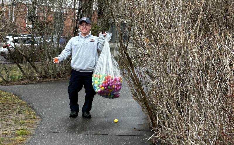 Camden Firefighter Noah Carlson, with a portion of the 3,000 eggs that were hidden earlier in the morning. c