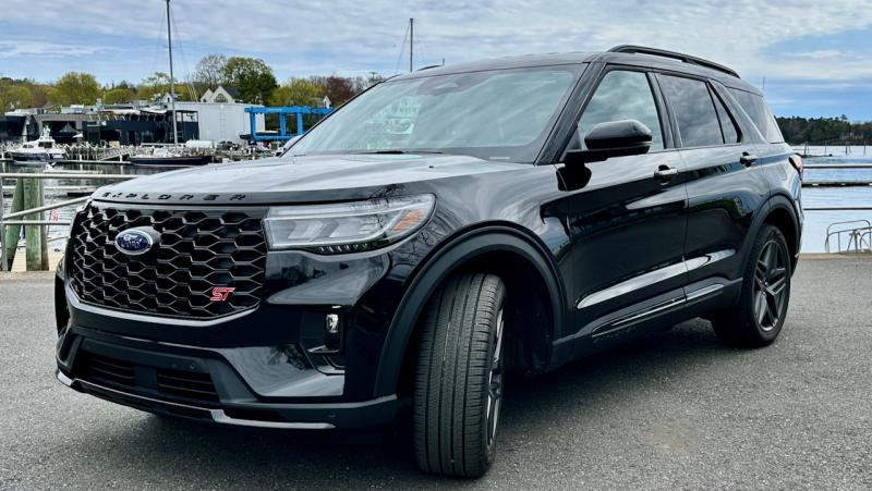 The red ST badge and black grille denote the 400-horsepower performance variant of the 2025 Ford Explorer; other visual clues include red brake calipers and these blacked-out 21-inch aluminum wheels. The view out over the high, squared-off nose is distinctly pickup-truck. This color is Agate black Metallic. The red ST badge and black grille denote the 400-horsepower performance variant of the 2025 Ford Explorer; other visual clues include red brake calipers and these blacked-out 21-inch aluminum wheels. The view out over the high, squared-off nose is distinctly pickup-truck. This color is Agate black Metallic.