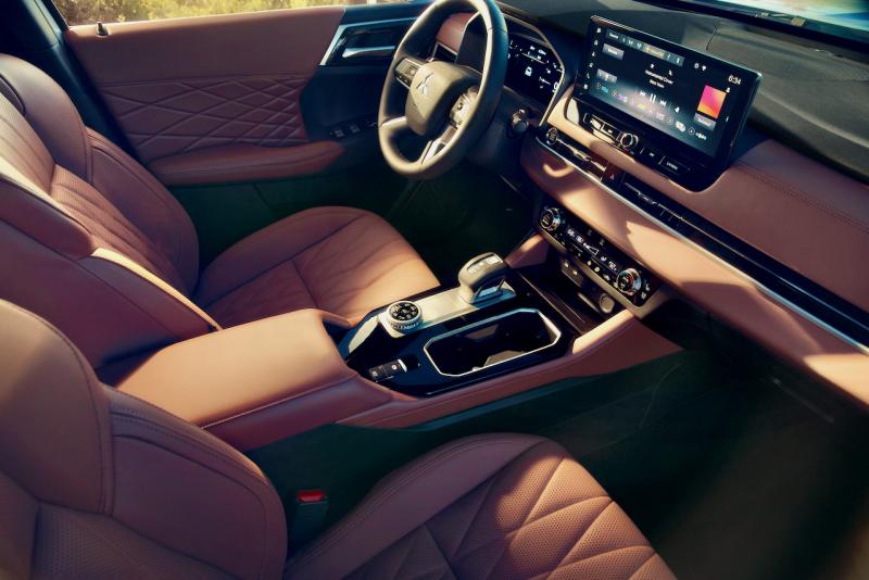 For 2025 the Outlander’s cabin was upgraded with premium-looking upholstery and other materials along with this 12.3-inch touchscreen. The satisfyingly mechanical-feeling push-pull gear selector has the Park button on top, and the e-brake switch is right there on the center console. The knob next to the drink-holder cubby is the drive-mode selector. For 2025 the Outlander’s cabin was upgraded with premium-looking upholstery and other materials along with this 12.3-inch touchscreen. The satisfyingly mechanical-feeling push-pull gear selector has the Park button on top, and the e-brake switch is right there on the center console. The knob next to the drink-holder cubby is the drive-mode selector.