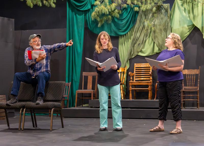 Theater seats stand in for junk in the Stillman yard at an early rehearsal of "One Blue Tarp". (L-r): Robert Smith (David Stillman), Emily LeBlanc-McConnell (Joan Stillman), and Julia Clapp (Judy Stillman). (Photo by Gwyneth Sauvage) Theater seats stand in for junk in the Stillman yard at an early rehearsal of "One Blue Tarp"