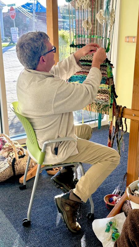 Visitor adding to a community tapestry on an Earth Loom. (Photo courtesy Rockport Public Library)
Visitor adding to a community tapestry on an Earth Loom. (Photo courtesy Rockport Public Library)