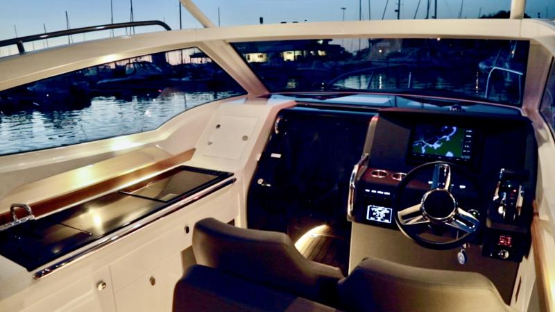 The helm station with its adjustable bucket seats. One large or two smaller computer screens are available, which show course and depth, boat speed, engine RPM, fuel consumption, trim and much, much more. In low visibility, a radar overlay on the chartplotter provides security, backed up by a VHF radio with AIS, Automatic Identification System. The galley, with its refrigerator, propane stove and shelves stocked with Nimbus dishes and flatware, is on the left. The sliding door leads to a comfortable V-berth cabin with storage space, ventilation, heat, lighting, sound and a full enclosed head (no shower). The helm station with its adjustable bucket seats. One large or two smaller computer screens are available, which show course and depth, boat speed, engine RPM, fuel consumption, trim and much, much more. In low visibility, a radar overlay on the chartplotter provides security, backed up by a VHF radio with AIS, Automatic Identification System. The galley, with its refrigerator, propane stove and shelves stocked with Nimbus dishes and flatware, is on the left. The sliding door leads to a comfortable V-berth