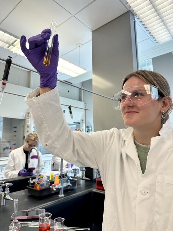 female holds up test tube in laboratory