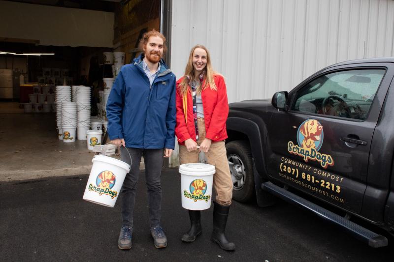 man, woman pose with buckets