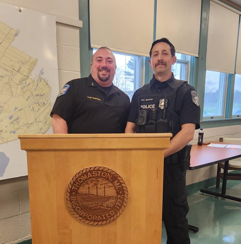 two men in uniform stand at lectern