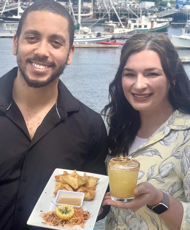 Man, woman hold appetizer, drink