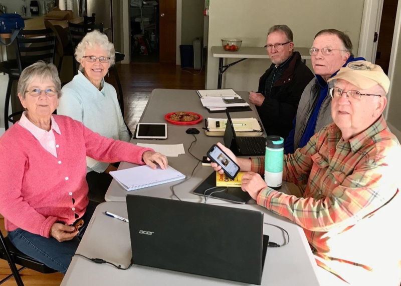 five adults sit at a table
