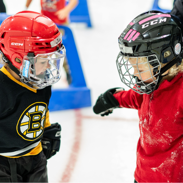 Two young skaters having fun learning to skate on ice.