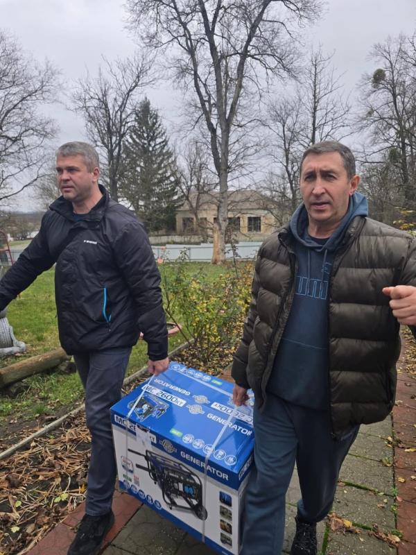 two adults carry a generator