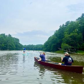 Canoe and paddle boarders row down a river. (Photo courtesy Maeve Cosgrove)
