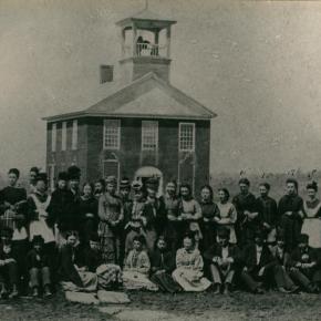 Black and white photo of students in front of a school