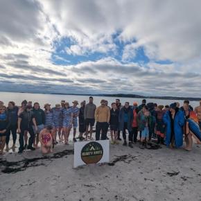 Large crowd of participants pose for a picture on the beach
